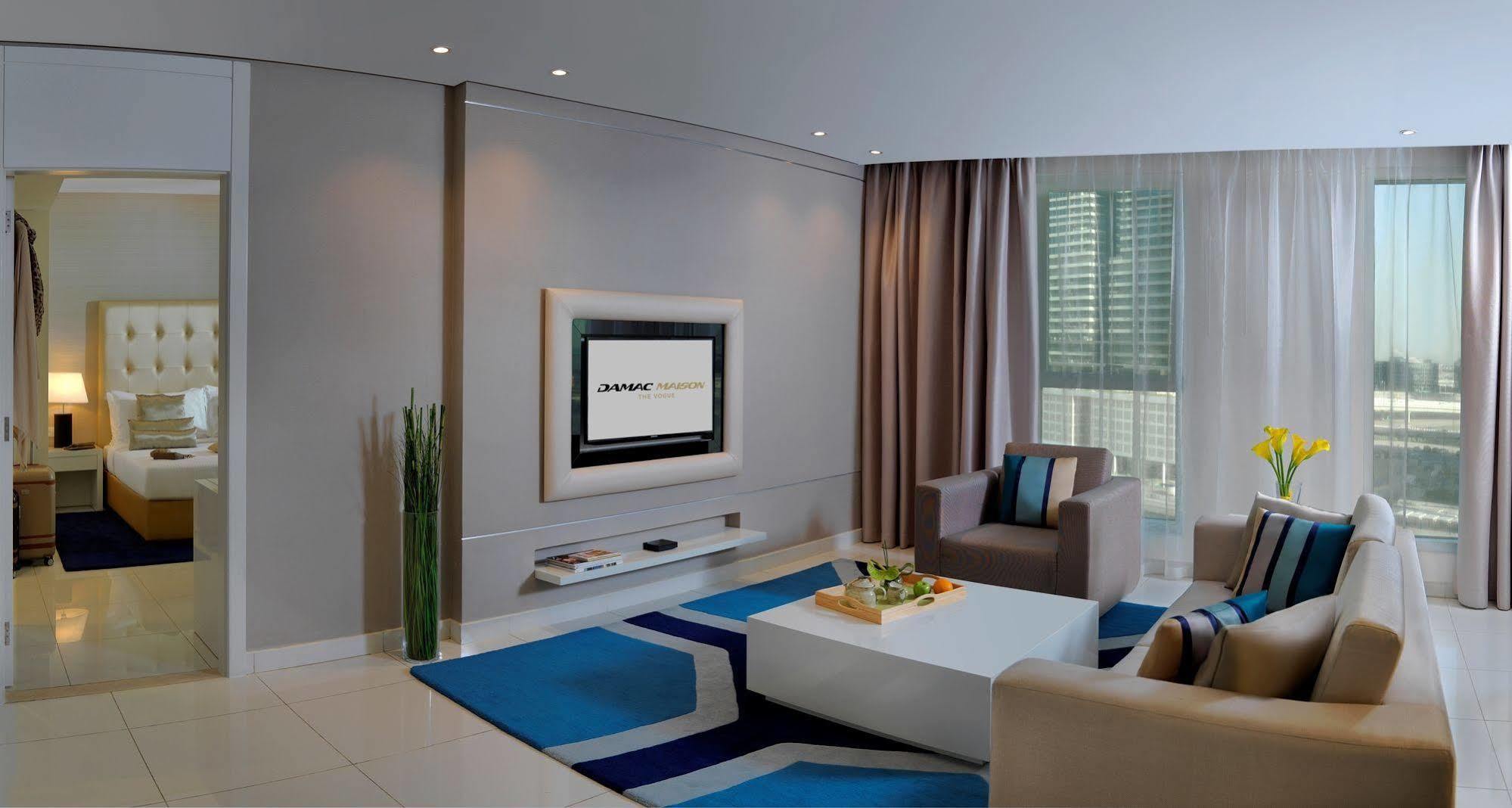 Damac Maison The Vogue Дубай Экстерьер фото A living room with a television